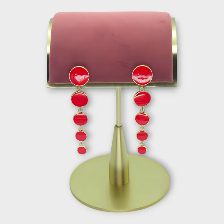 Riva Cascade earrings with cascading red circular accents on a gold stand display.