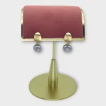 A pair of Auralis Drop earrings with gold-tone studs and silver spherical drops on a display stand.