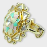 Side view of STONIRA adjustable gold statement ring featuring a hand-enameled pastel lotus blossom surrounded by a geometric starburst of clear crystals