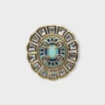 Overview of STONIRA adjustable gold medallion ring featuring a turquoise center, blue enamel work, and a sunburst of geometric crystals