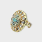 Side view of STONIRA adjustable gold medallion ring featuring a turquoise cat's eye center, blue enamel work, and a sunburst of geometric crystals