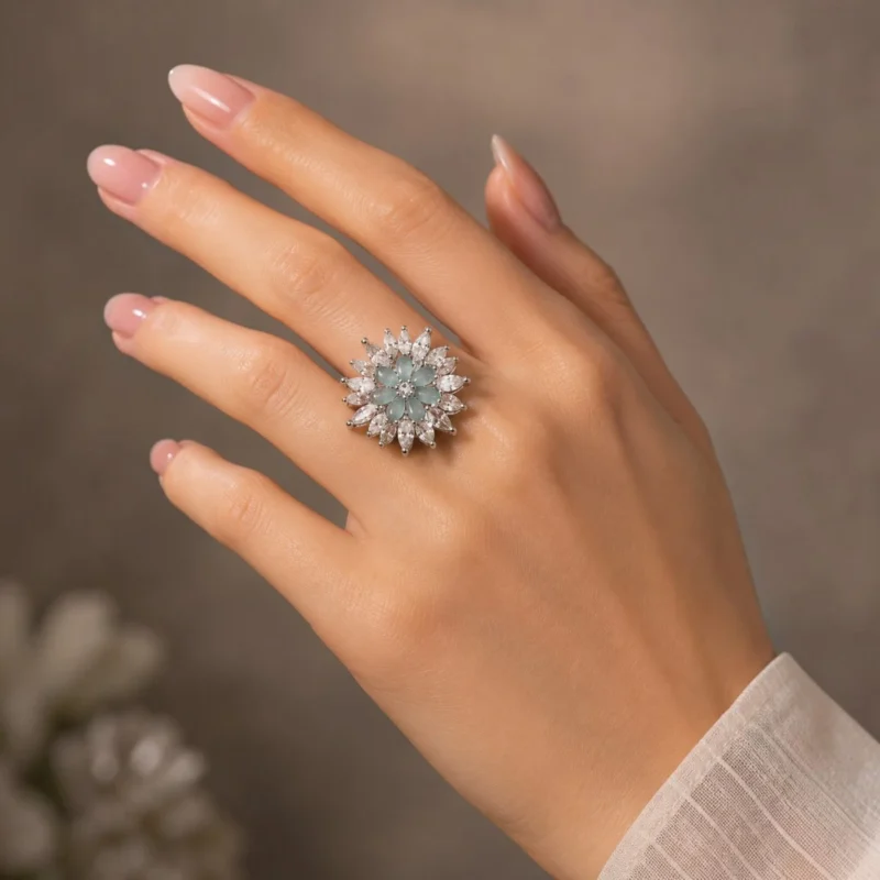Women wearing STONIRA silver cocktail ring featuring a central mint green gemstone flower surrounded by a dramatic starburst halo of clear marquise crystals