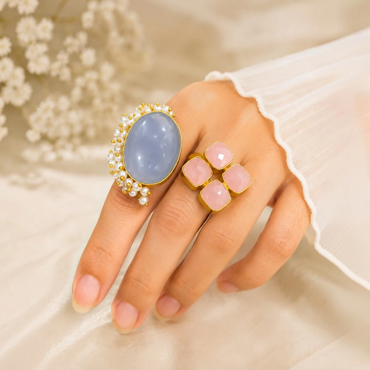 ChatGPT Image Jun 27, 2026, 10_44_35 PM STONIRA adjustable statement ring featuring a large Blue Chalcedony gemstone, Rose Quartz accents, pearl detailing, and a gold-tone setting worn on hand.