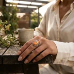 Women wearing STONIRA adjustable silver cocktail ring featuring a rectangular orange cat's eye stone and crystal pavé ribbons