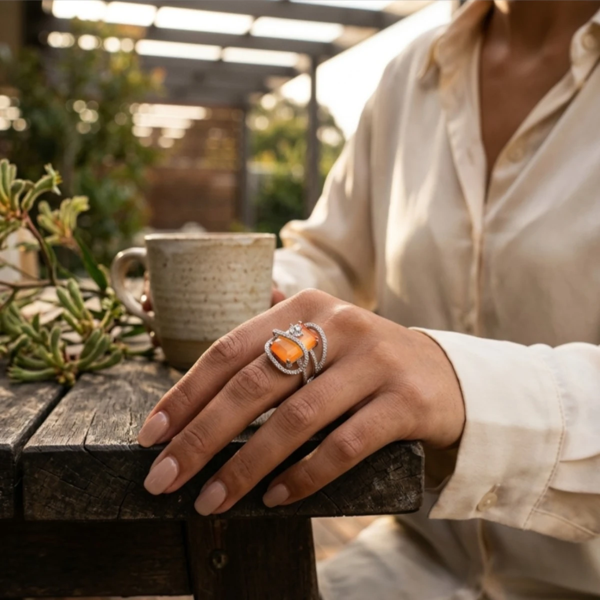 Gemini_Generated_Image_3ntdk63ntdk63ntd Women wearing STONIRA adjustable silver cocktail ring featuring a rectangular orange cat's eye stone and crystal pavé ribbons