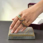 Women wearing STONIRA peacock-inspired adjustable two-finger statement ring featuring turquoise enamel detailing, multicolour crystal accents, gold-tone finish, and an elegant peacock feather design.