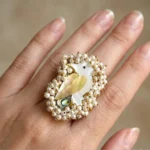 Women wearing Swan-inspired pearl statement ring in gold-tone finish