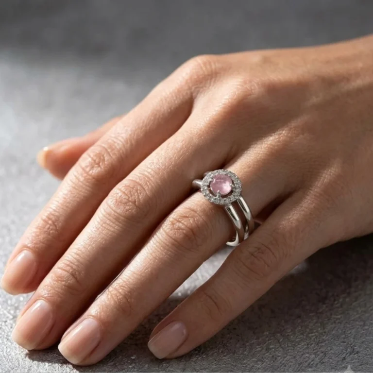 Women wearing STONIRA pink quartz silver bypass ring with sparkling micro pave halo backdrop