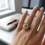 Women wearing STONIRA adjustable gold cocktail ring featuring a concentric circular design of multi-colored gemstones and a white pearl halo