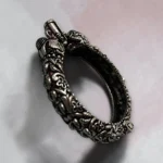 Detailed side profile of STONIRA antique oxidised silver bangle with raised floral carvings side view