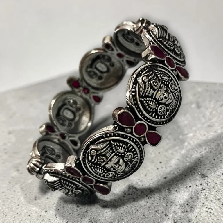 Overview of STONIRA oxidised silver coin statement bangle with pink stone inlays