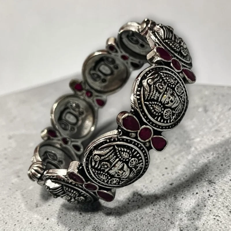 Overview of STONIRA oxidised silver coin statement bangle with pink stone inlays