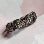 Side view of STONIRA oxidised silver coin statement bangle with pink stone inlays