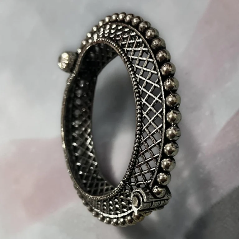 Side view of the STONIRA oxidised silver lattice hinged statement bangle