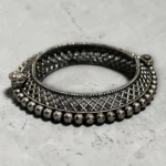 Detailed view with beads of the STONIRA oxidised silver lattice hinged statement bangle