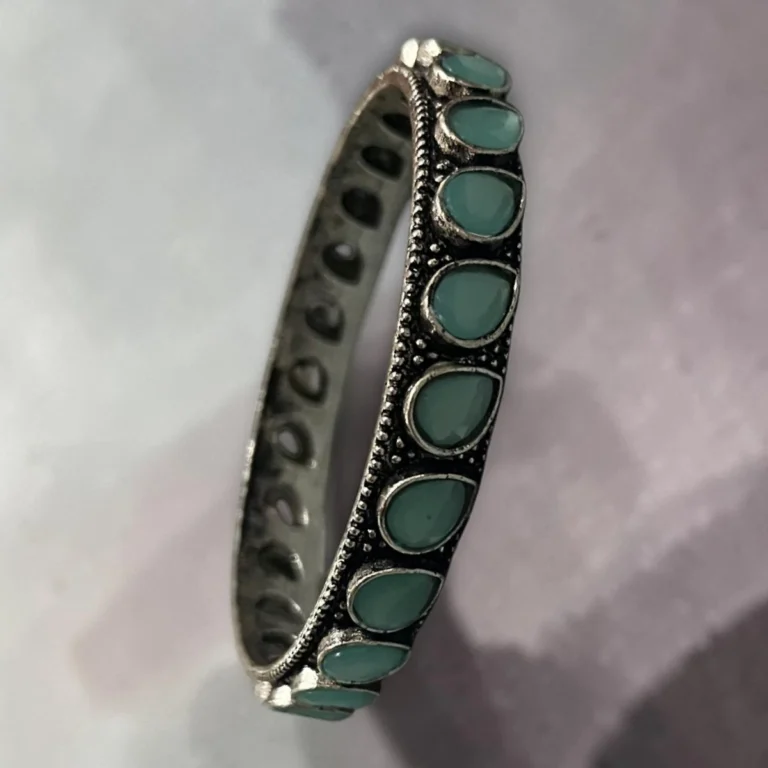 Side view of oxidised silver slip-on bangle inlaid with soft mint green stones in size 2.4