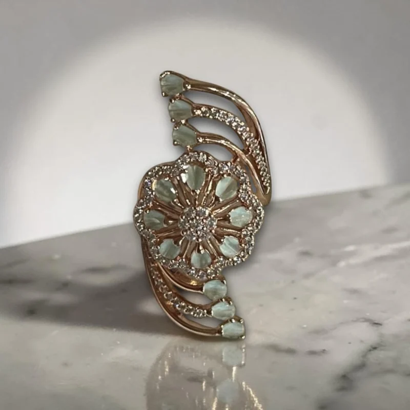 Women wearing STONIRA adjustable gold cocktail ring with a mint green stone floral rosette and crystal-paved arches