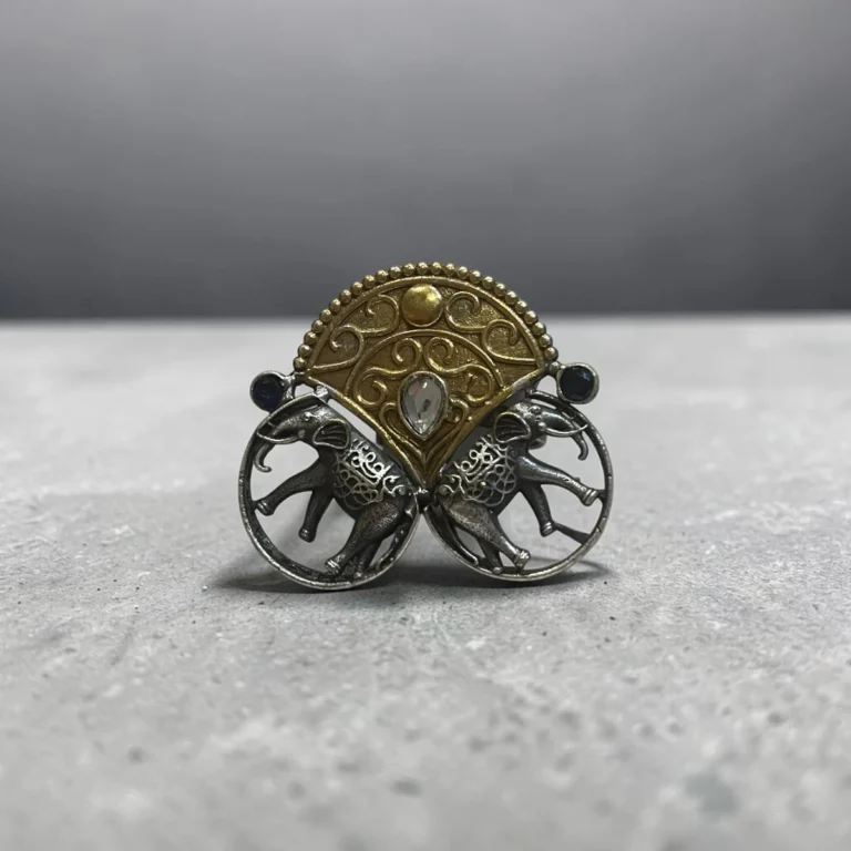 STONIRA adjustable mixed-metal cocktail ring featuring oxidized silver elephants, a golden archway, and sapphire crystal accents
