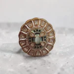 STONIRA adjustable gold medallion ring featuring a turquoise cat's eye center, blue enamel work, and a sunburst of geometric crystals