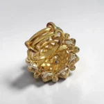Back of STONIRA adjustable gold statement ring featuring a hand-enameled pastel lotus blossom surrounded by a geometric starburst of clear crystals
