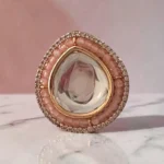 STONIRA adjustable gold statement ring featuring a teardrop-cut central Kundan gem surrounded by peach beads and a micro-pave crystal halo