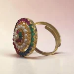 Angle view of STONIRA adjustable gold cocktail ring featuring a concentric circular design of multi-colored gemstones and a white pearl halo