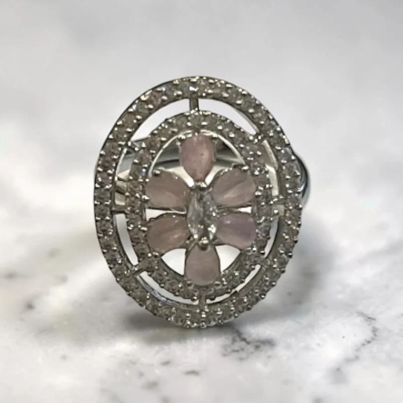 STONIRA silver cocktail ring with an oval pavé border featuring a central rose quartz flower and marquise-cut crystal bud