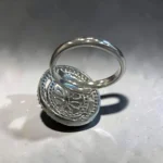 Back of STONIRA silver cocktail ring with an oval pavé border featuring a central rose quartz flower and marquise-cut crystal bud