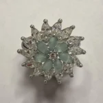 STONIRA silver cocktail ring featuring a central mint green gemstone flower surrounded by a dramatic starburst halo of clear marquise crystals