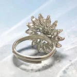 Back of STONIRA silver cocktail ring featuring a central mint green gemstone flower surrounded by a dramatic starburst halo of clear marquise crystals
