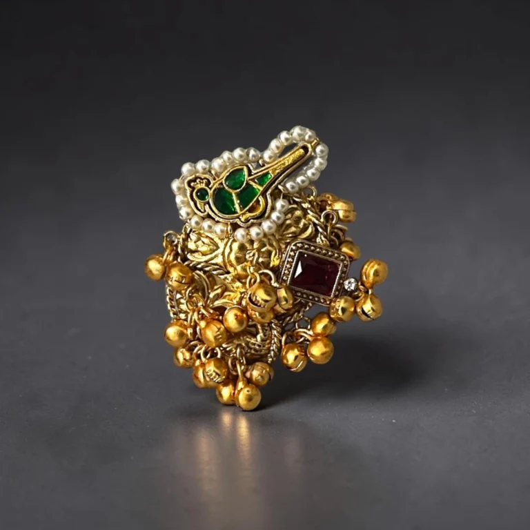 STONIRA adjustable gold temple charm ring featuring red gemstone, pearl accents, intricate heritage motifs and ghungroo detailing for festive and wedding wear.
