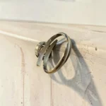 Back view of STONIRA pink quartz silver bypass ring with sparkling micro pave halo backdrop