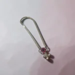 Angle-view-of-the-STONIRA-silver-payal-anklet-highlighting-the-pink-enamel-charm-and-three-small-hanging-silver-bells