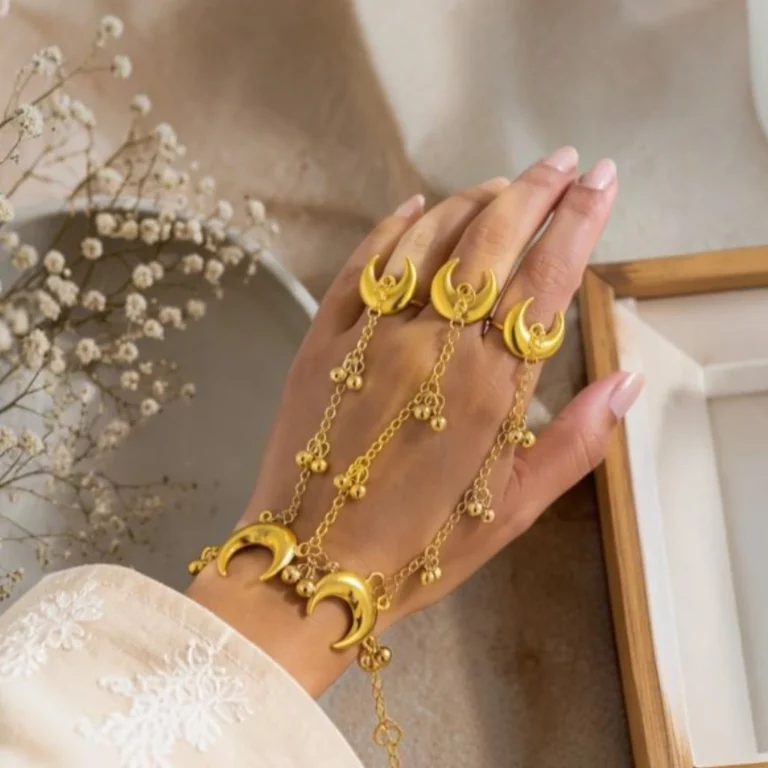 Close-up-of-gold-crescent-moon-motifs-and-ghungroo-bells-on-fine-chain-hand-harness.