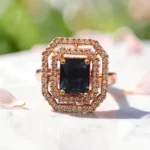Close-up-of-the-STONIRA-rose-gold-polished-navy-blue-statement-ring-worn-on-a-hand-highlighting-the-deep-blue-rectangular-gemstone-and-double-crystal-halo