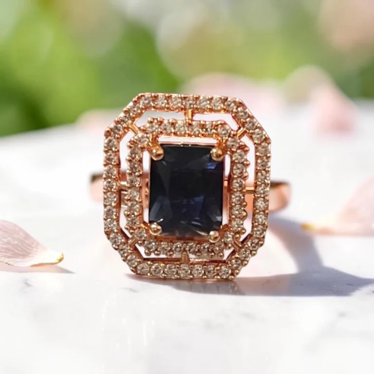 Close-up-of-the-STONIRA-rose-gold-polished-navy-blue-statement-ring-worn-on-a-hand-highlighting-the-deep-blue-rectangular-gemstone-and-double-crystal-halo