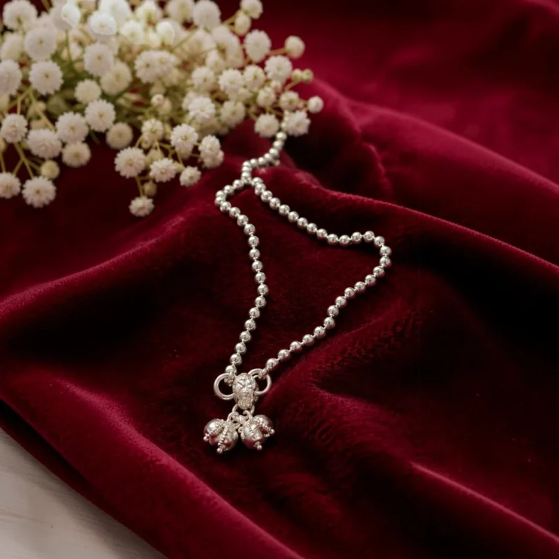 STONIRA-modern-silver-spherical-bead-payal-anklet-laid-on-smooth-fabric
