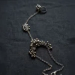 STONIRA oxidised silver ghungroo haathphool hand harness bracelet featuring bead cluster embellishments and adjustable finger ring