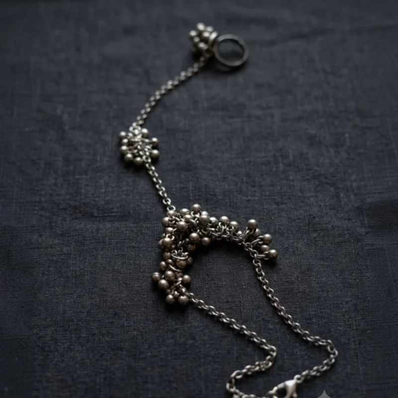 STONIRA oxidised silver ghungroo haathphool hand harness bracelet featuring bead cluster embellishments and adjustable finger ring