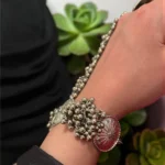Side view of STONIRA oxidised silver floral hathphool hand harness bracelet featuring sunburst medallions and dense ghungroo bell clusters