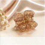 Champagne shimmer resin butterfly hair claw clip with gold-tone spring on marble