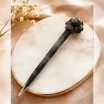 Charcoal grey textured resin hair stick with a sculpted knot accent for buns and updos.