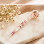 Clear resin hair stick with delicate pink pressed flower inclusions and a sculpted knot accent