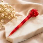 Crimson red resin hair stick with a sculpted knot centerpiece.