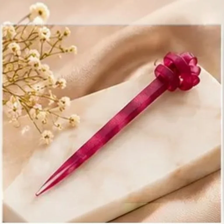 Deep ruby plum resin hair stick with a sculpted knot top designed