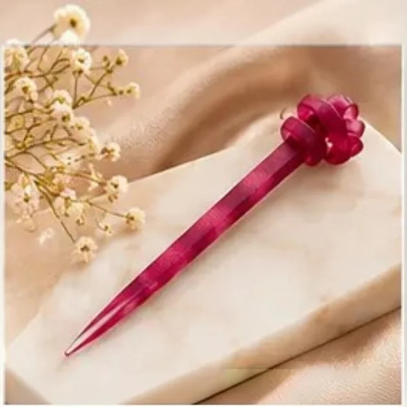 Deep ruby plum resin hair stick with a sculpted knot top designed