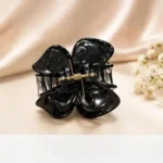 High-gloss obsidian black resin butterfly hair claw clip against a neutral background