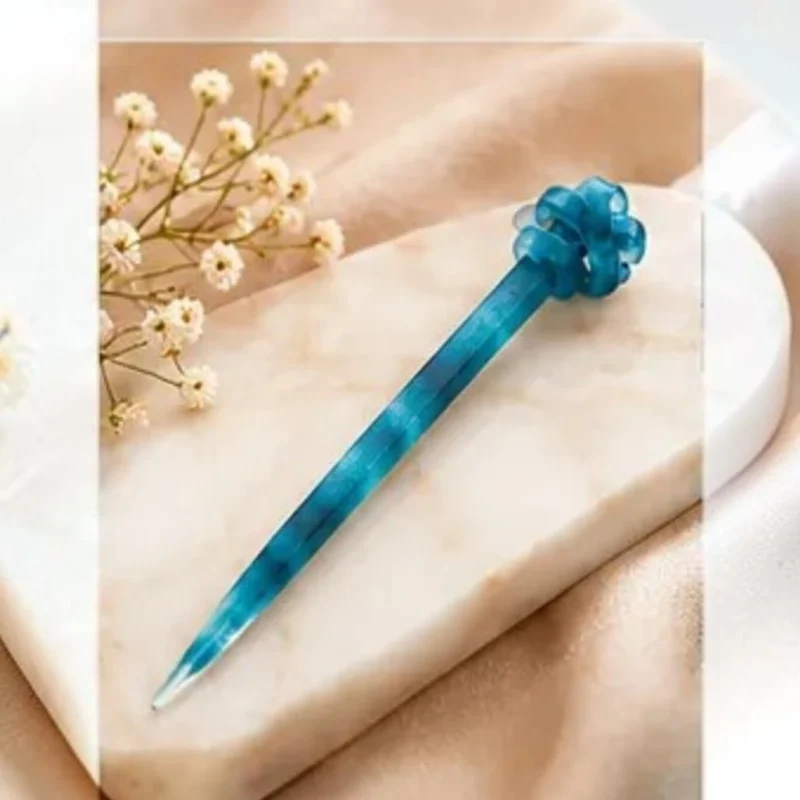 Ocean blue swirl resin hair stick featuring a hand-finished sculpted knot top for buns.