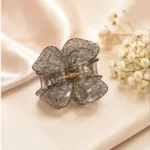 Smoky charcoal grey resin butterfly hair claw clip with gold hardware detail.