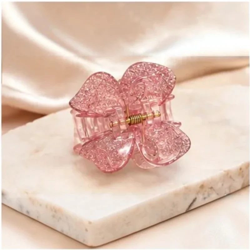 Soft rose quartz pink resin butterfly hair claw clip with delicate glitter flecks.